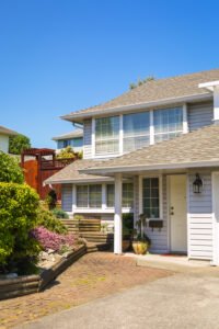 Front entrance of family house with flowers on blue sky background